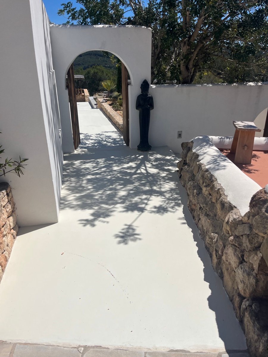 Smooth white finished walkway leading through an arch