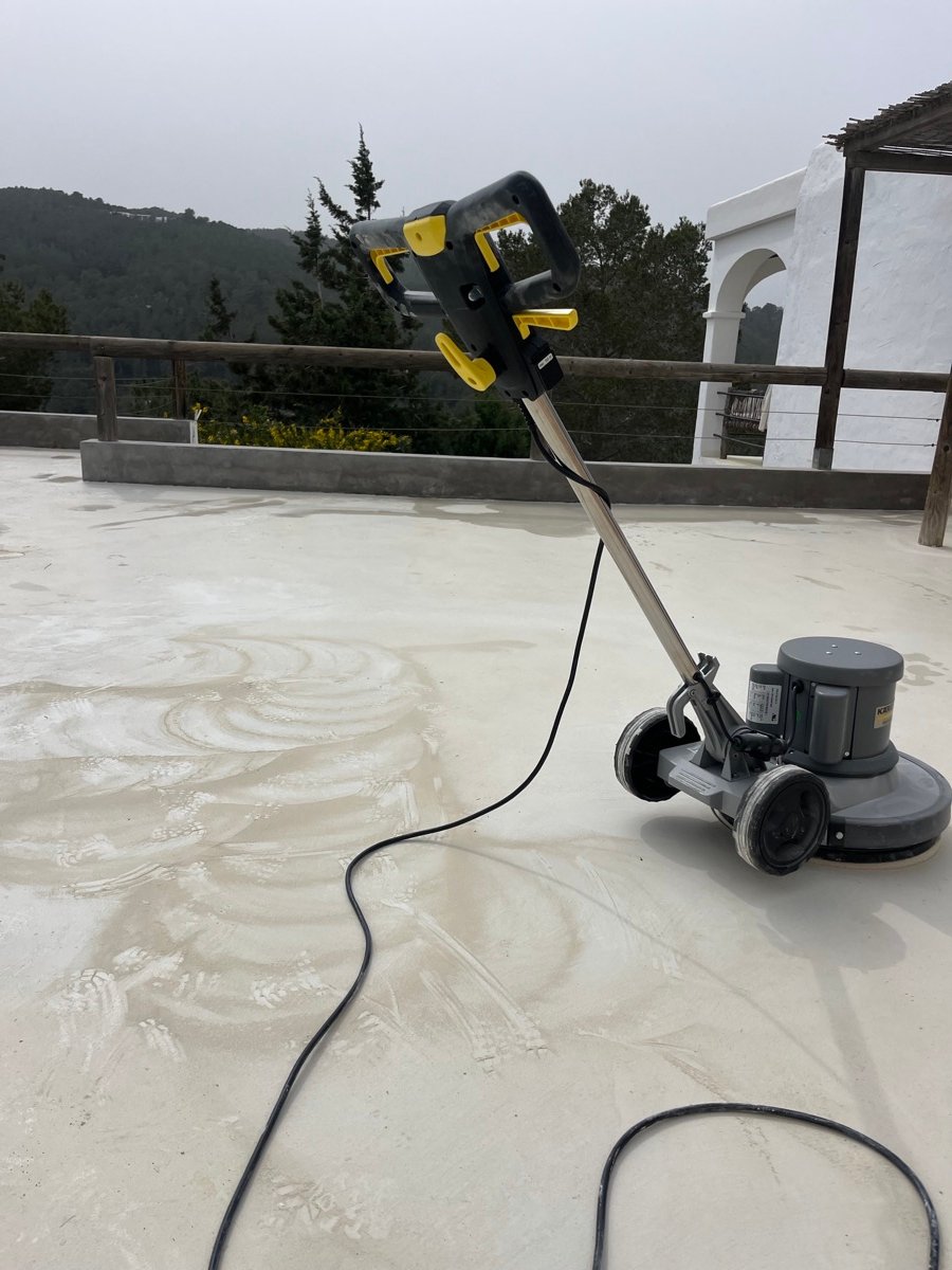 Orbital machine polishing a rooftop terrace with mountain views
